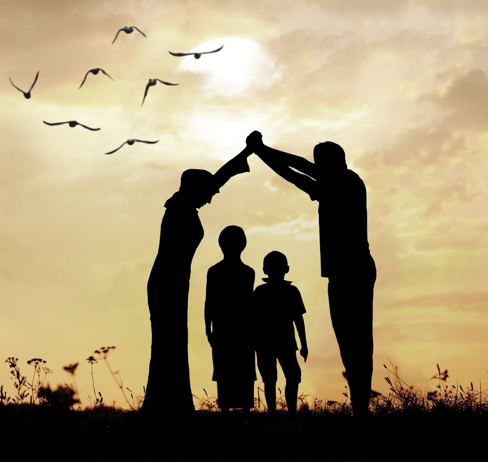 Silhouette einer Familie unter einem schützenden Dach vor Sonnenuntergang – Symbol für Datenschutz und Vertrauen im Kinder-Schlafcoaching.