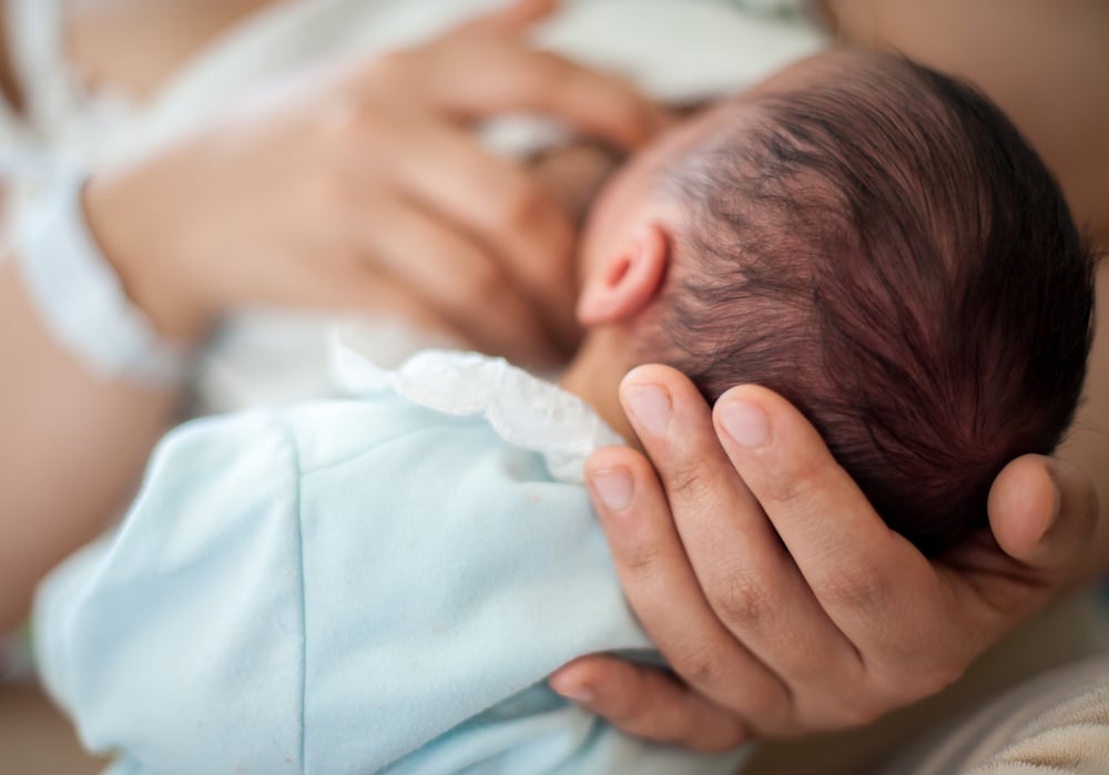 Alt-Text: Glückliches Baby im Arm der Mutter nach dem Schlafcoaching für 9 Monate alte Babys – Erfolg bei nächtlichem Erwachen.