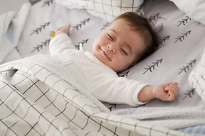 ufriedenes Baby schläft entspannt in seinem Bettchen nach dem erfolgreichen Abschluss des Schlafcoachings